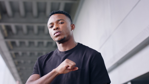 Portrait of black man with respect gesture outdoors in city, black lives matter concept.