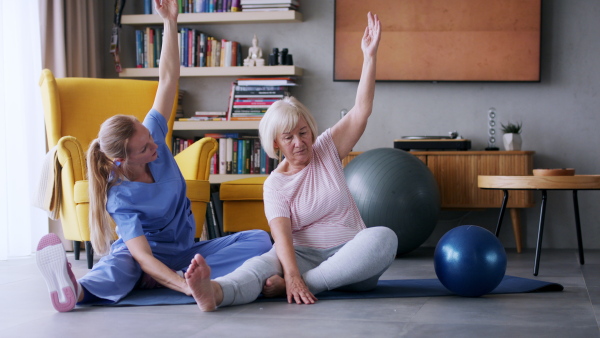 Portrait of senior woman exercising with personal trainer.