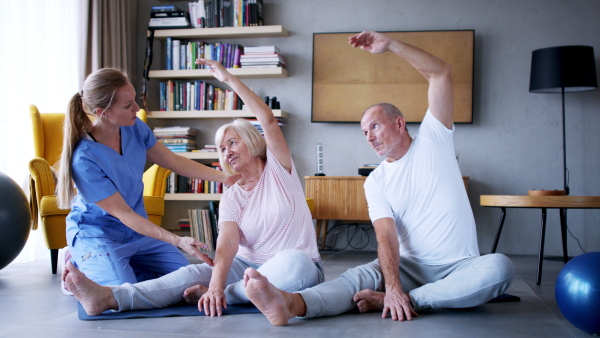 Portrait of senior man exercising with personal trainer.