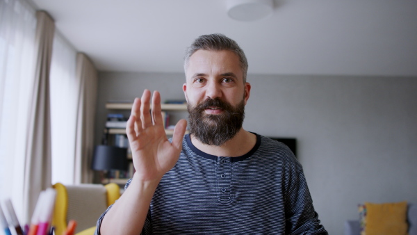 Portrait of a man working at home, having a call, looking at camera. Homeoffice concept