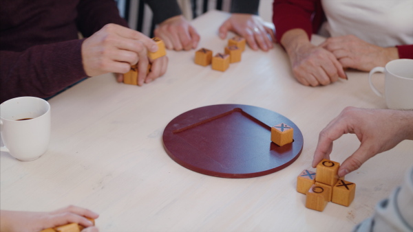 A group of young and old people playing board games at community centre, midsection.