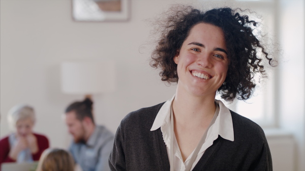 A portrait of cheerful young woman at community centre, looking at camera.