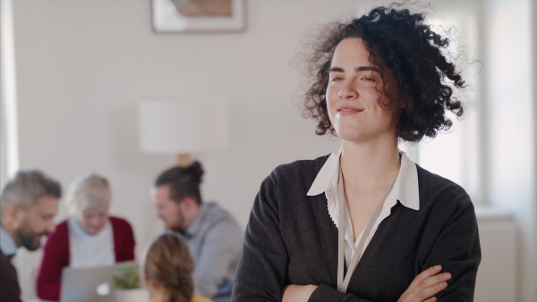 A portrait of cheerful young woman at community centre, looking at camera.