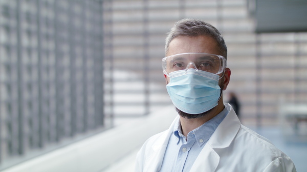 A front view of man with face mask looking at camera, corona virus concept.