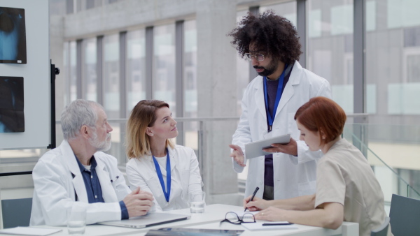 A group of doctors with laptop at the desk discussing issues.