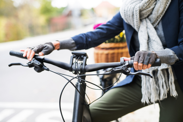 A midsection view of senior woman with electrobike outdoors in town.