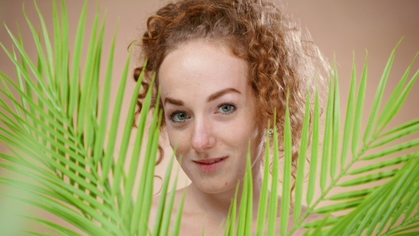 Portrait of topless young woman in a studio looking at camera, beauty concept.