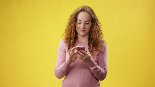 Portrait of young woman using smartphone in a studio.