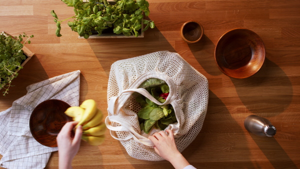 Top view of unrecognizable young woman unpacking a purchase.