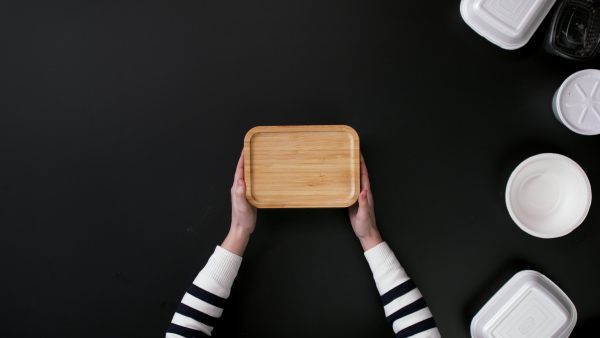 Top view of unrecognizable young woman opening a lunch. Sustainable lifestyle concept.