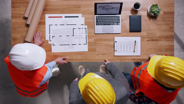 Top view of two architects and client discussing about housing project. Copy space.