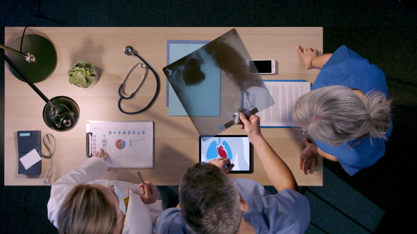 Top view of unrecognizable medical workers having a discussion about patients health condition.