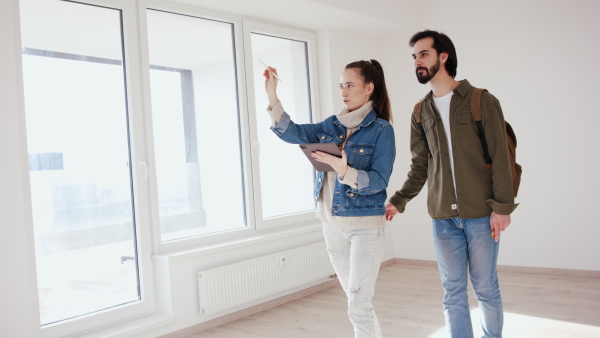 Happy young couple with tablet moving and planning in new flat, new home and relocation concept.