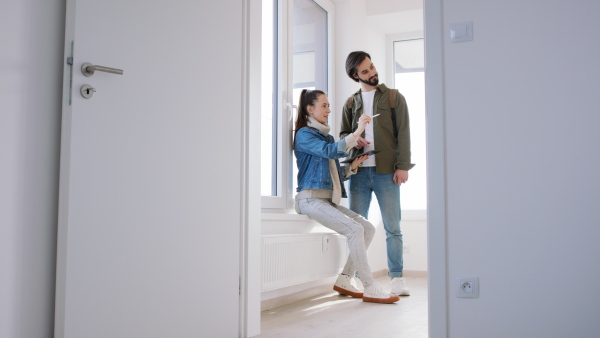 Happy young couple with tablet moving and planning in new flat, new home and relocation concept.