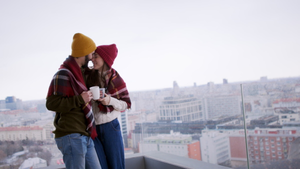 Happy young couple owners with coffee on balcony in new flat, moving in, new home and relocation concept.