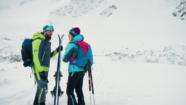 A ski touring couple in love taking break on the top of mountain in the Low Tatras in Slovakia.