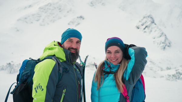 A ski touring couple in love taking break on the top of mountain in the Low Tatras in Slovakia.