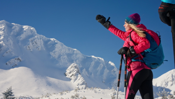 A female backcountry skier hiking to the summit of a snowy peak in the Low Tatras in Slovakia.