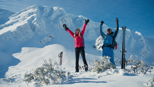 A ski touring couple high fiving on the top of mountain in the Low Tatras in Slovakia.