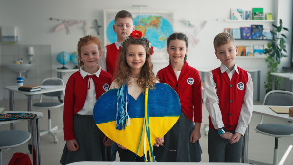 Schoolchildren welcoming a new Ukrainian classmate, concept of enrolling Ukrainian kids to schools.