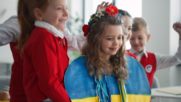 Schoolchildren welcoming a new Ukrainian classmate, concept of enrolling Ukrainian kids to schools.