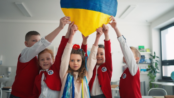 Schoolchildren welcoming a new Ukrainian classmate, concept of enrolling Ukrainian kids to schools.