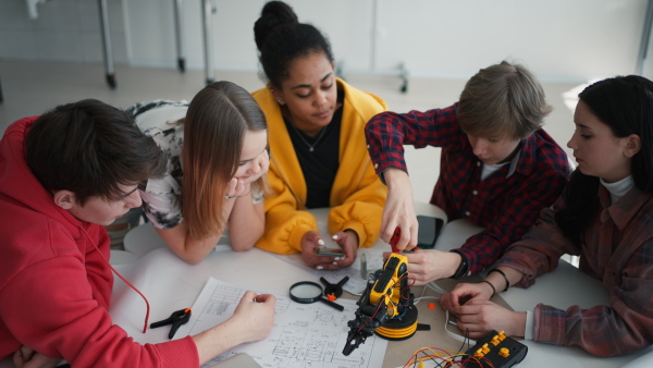 A group of students building and programming electric toys and robots at robotics classroom