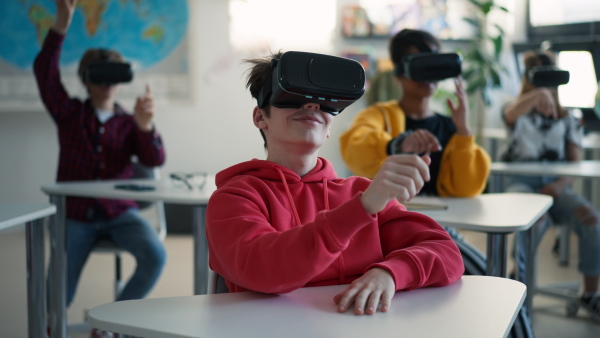 Teenage students wearing virtual reality goggles at school in a computer science class