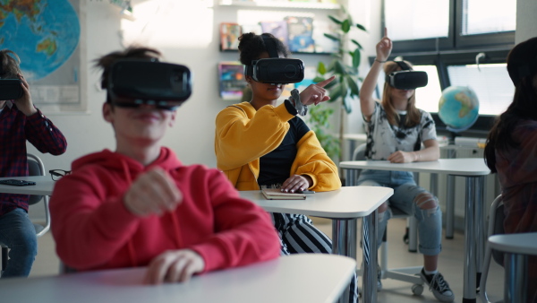 Teenage students wearing virtual reality goggles at school in a computer science class