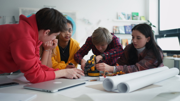 A group of students building and programming electric toys and robots at robotics classroom