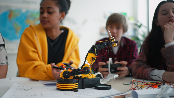 A group of students building and programming electric toys and robots at robotics classroom