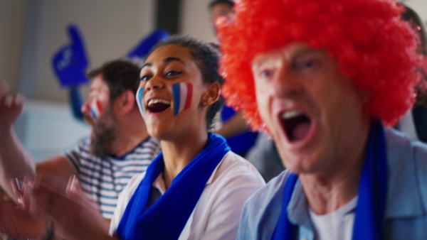 French football fans celebrating their team's victory at a stadium.