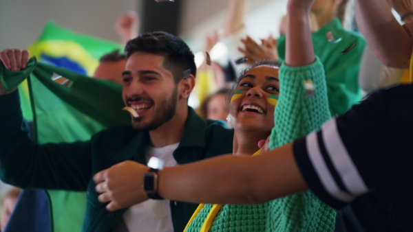 Brazilian young football fans celebrating their team's victory at a stadium.