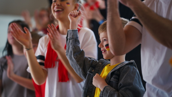 German football fans celebrating their team's victory at a stadium.