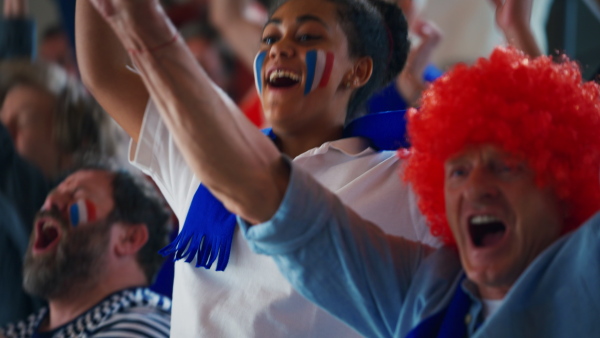 French football fans celebrating their team's victory at a stadium.