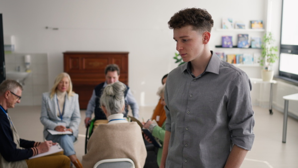 A young teacher with group of seniors at choir rehearsal.