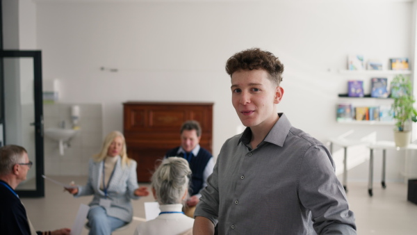 A young teacher with group of seniors at choir rehearsal.