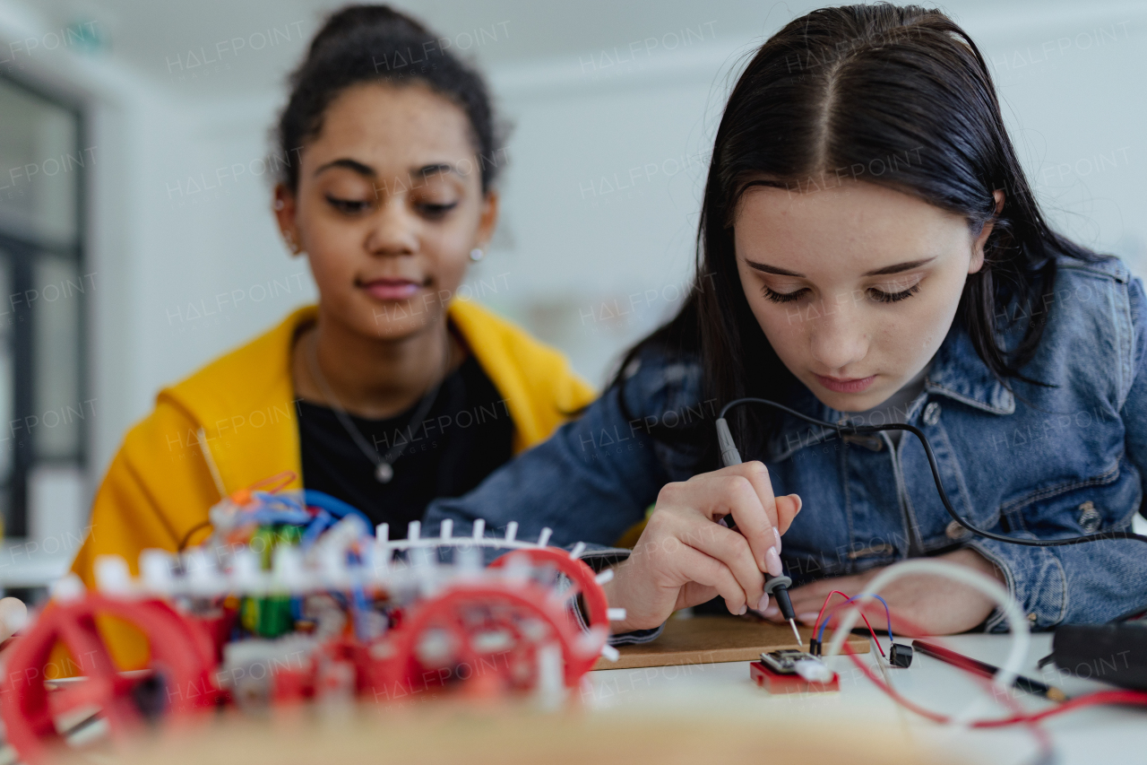 A high school students building and programming electric toys and robots at robotics classroom