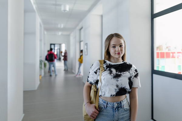 Young high school student walking in a corridor at school, back to school concept.