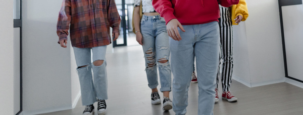 Young high school students walking in a corridor at school, back to school concept.