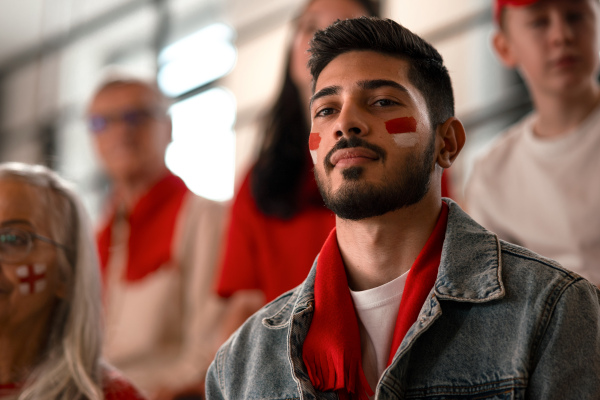 Excited football fans supproting an Monaco national team in live soccer match at stadium.