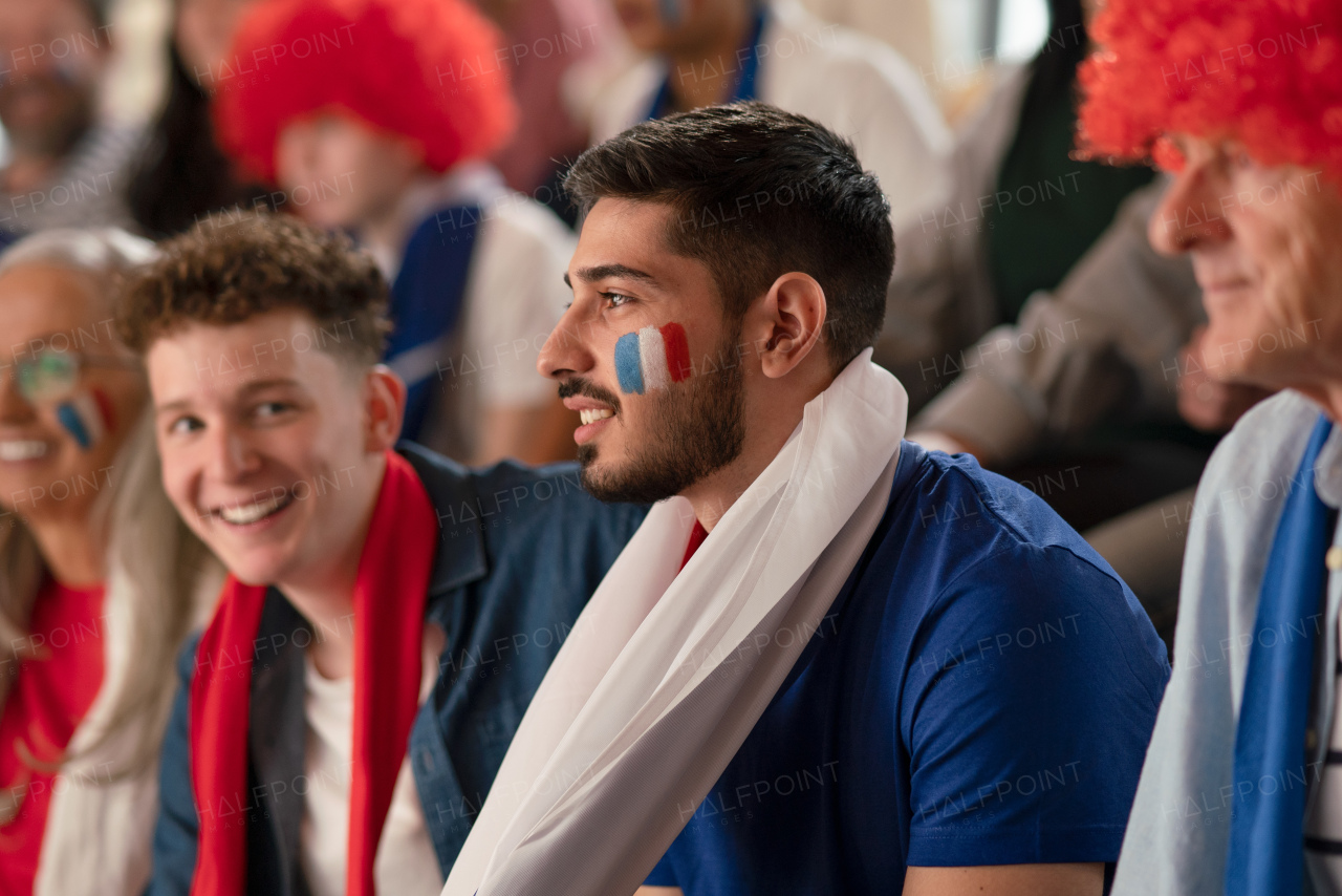 French football fans celebrating their team's victory at a stadium.