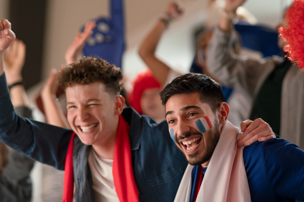 French football fans celebrating their team's victory at a stadium.