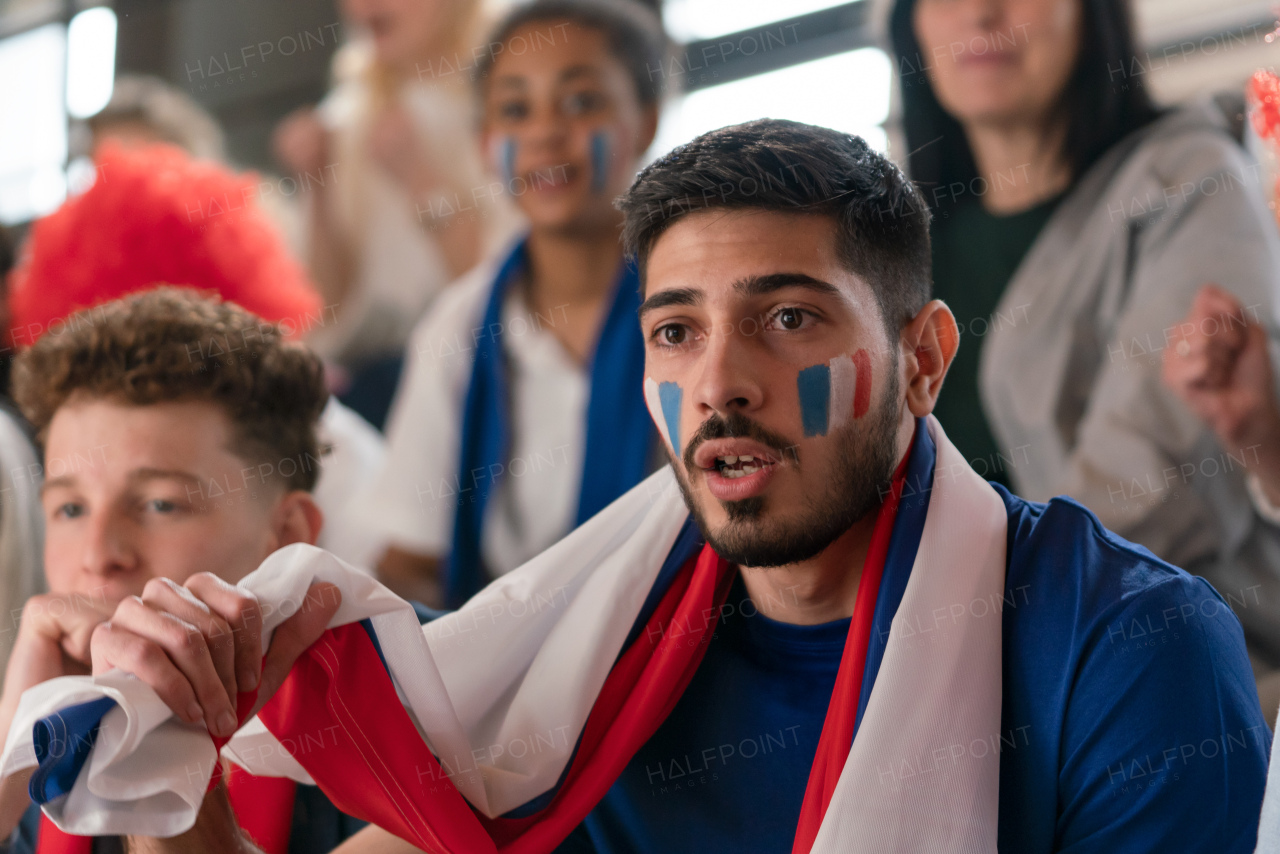 French football fans celebrating their team at a stadium.