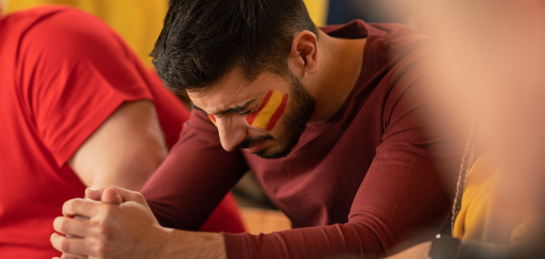 Sad football fan sitting at football stadium a spanish national team in live soccer match.