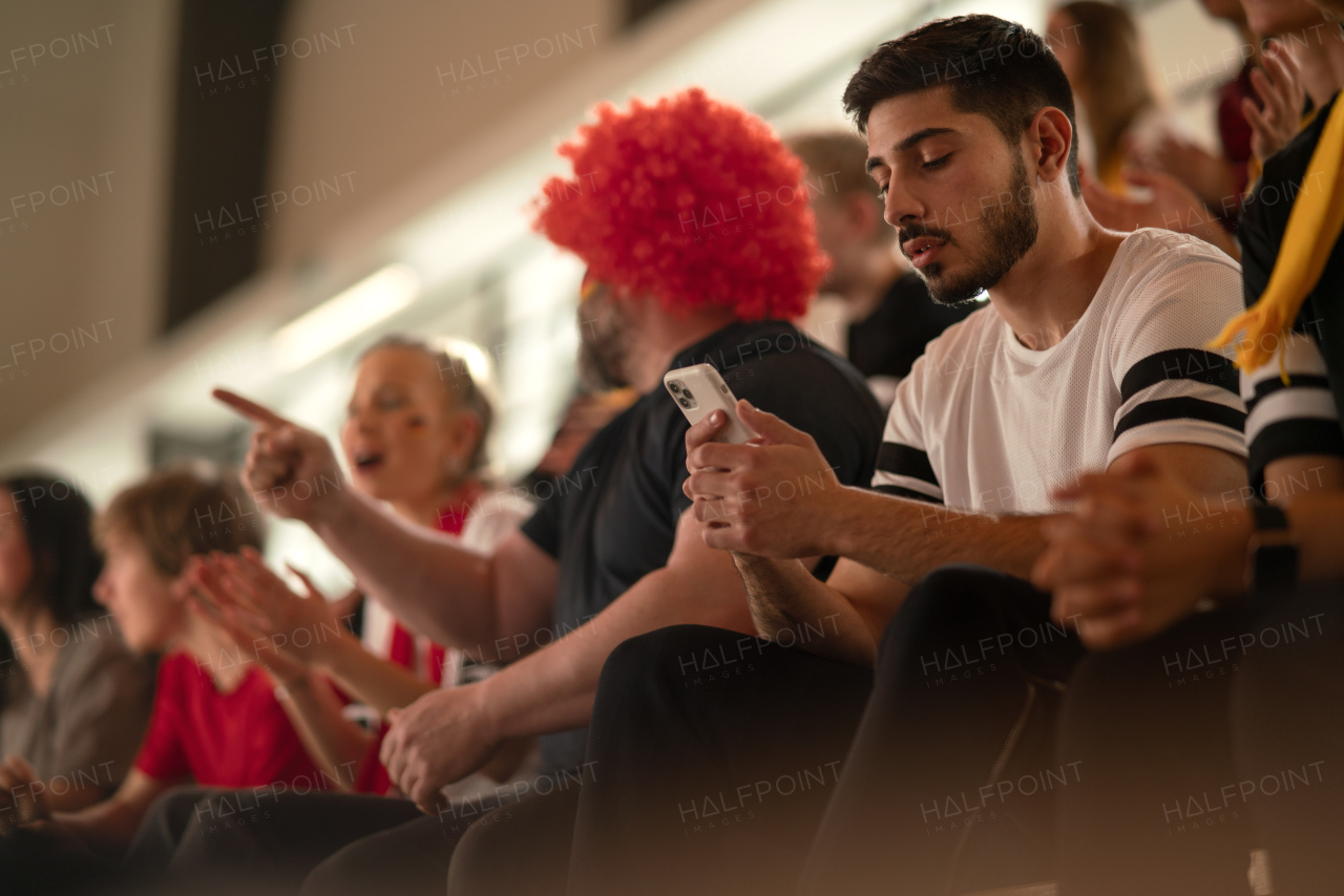 Worried football fans supproting a German national team in live soccer match at stadium.