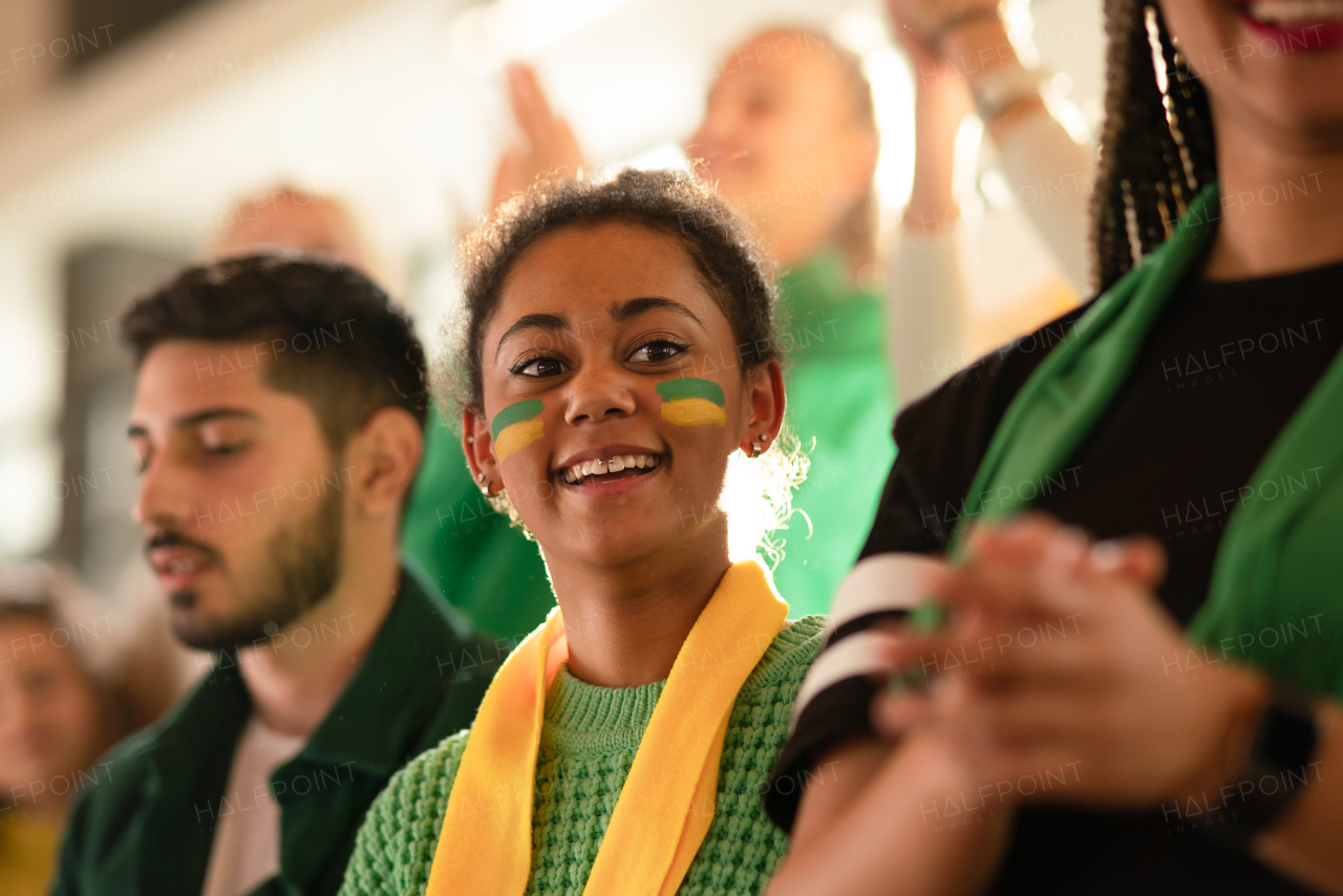 Brazilian young sisters football fans supporting their team at a stadium.