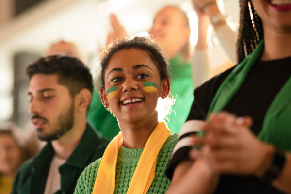 Brazilian young sisters football fans supporting their team at a stadium.