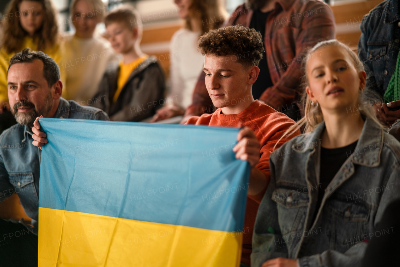 Ukrainian fans supproting national team in live match at a stadium.