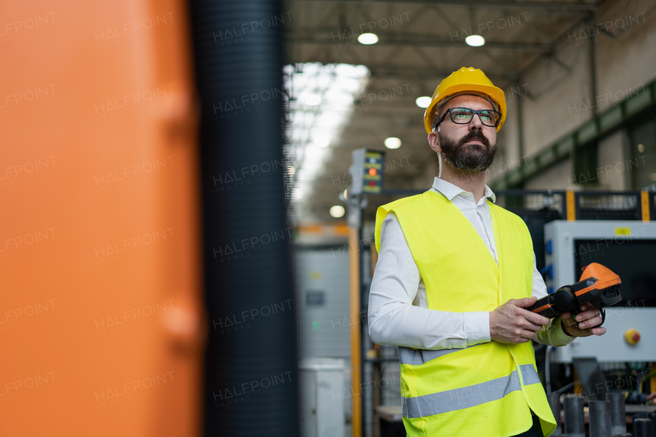 An automation engineer holding scanner in industrial in factory.